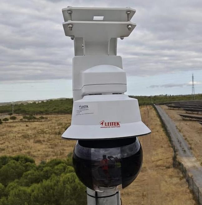 SafeForest Helios PTZ dome camera on a pole overlooking a solar park