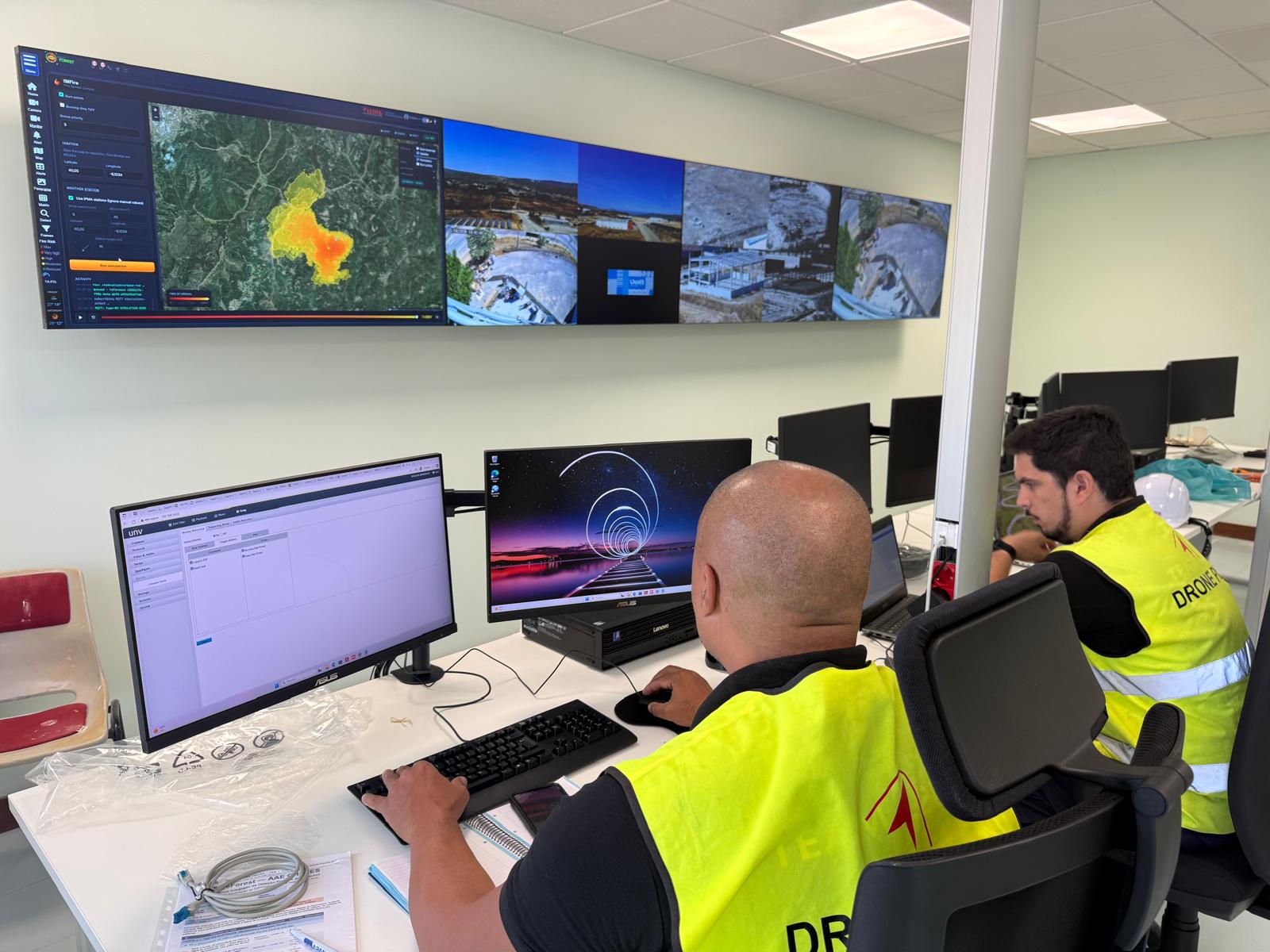 SafeForest control room — operators in front of a video wall showing the fire-spread simulation and live camera feeds